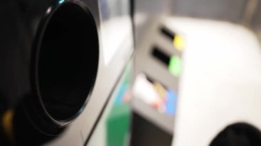 Kadın şişeyi otomatik şişe geri dönüşüm makinesine koyar. Geri dönüşüm otomatını tersine çevir.