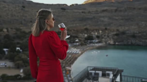 バルコニーに赤ワインのサングラスで女性 — ストック動画