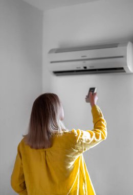 Uzaktan kumanda Klima havalandırma amaçlı tutan kadın.