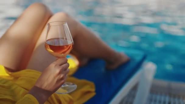 スイミングプールでリラックスしたワインを持つ女性 ストック映像
