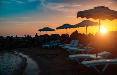 Gün batımında güneşli küçük kumlu plajlar.