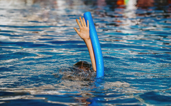 The hand of a drowning child in the pool.