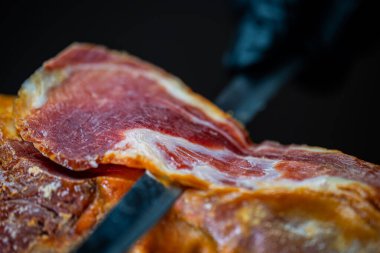 Şef kurutulmuş İspanyol jambonu kesiyor..