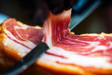 Şef kurutulmuş İspanyol jambonu kesiyor..