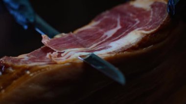 Şef kurutulmuş İspanyol jambonu kesiyor..
