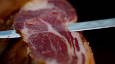Şef kurutulmuş İspanyol jambonu kesiyor..