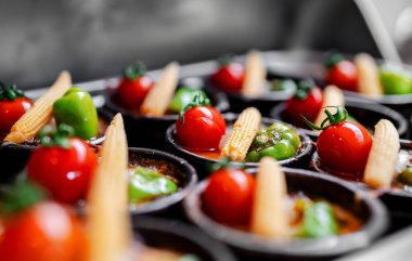 Domates, paprika ve mısırla kaplı fırında patates graten..