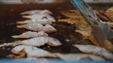 Taze hırpalanmış balık ızgarada kızarıyor..