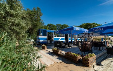 Narva-Joesuu, Estonia - 26.06.2024: Tram converted into a restaurant on the beach. clipart