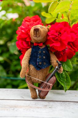 Handmade craft bear with violin. Children's toy. clipart