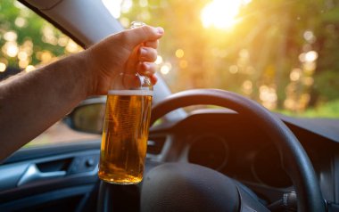 Arabada bira şişesi olan bir adam. Sarhoş araba kullanma konsepti.