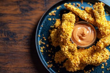 Altın kabuklu ve soslu çıtır tavuk şeritleri..