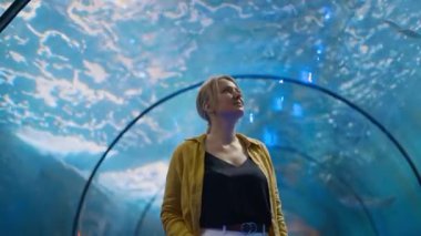 Bir kadın sualtı tünelinde deniz dünyasını keşfediyor..