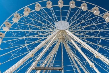 Dönme dolap açık mavi gökyüzüne karşı.