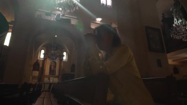 Kadın kilisede oturmuş dua ediyor..