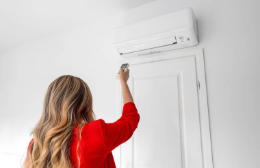 Uzaktan kumanda Klima havalandırma amaçlı tutan kadın.