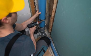 Yeni bir kanalizasyon borusu döşeyen bir adam.