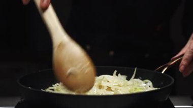 Sıcak tavada yağlı dilimlenmiş soğan kızartması..