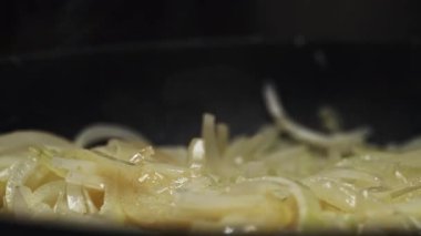 Sıcak tavada yağlı dilimlenmiş soğan kızartması..