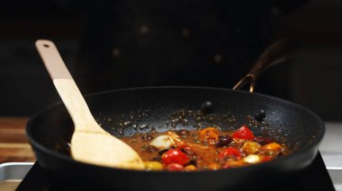 Kızarmış vişneli domates ve zeytin kızartma tavasında..