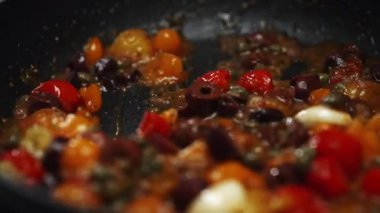 Kızarmış vişneli domates ve zeytin kızartma tavasında..