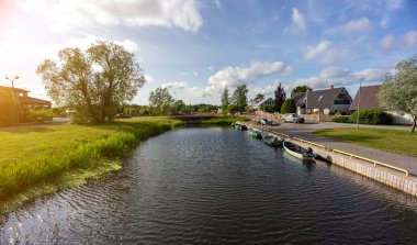 Etrafı yeşilliklerle çevrili teknelerle dolu sakin bir nehir..