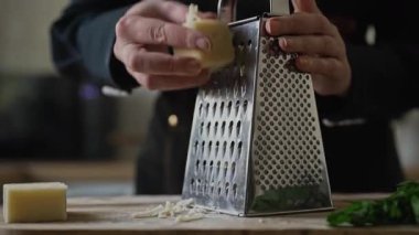 Metal mutfak rendesinde rendelenmiş peynir..