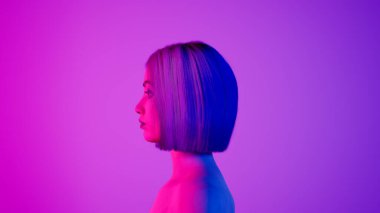 Kadın hiper-gerçekçi robot ya da sayborg stüdyoda neon ışıkla dönüyor. Sibernetik kızdaki yapay zeka ya da sinirsel ağ. Dijital teknoloji konsepti. Kusursuz 3D döngü oluşturucu.