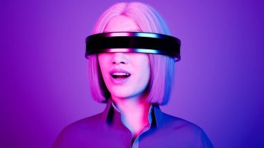 Teknoloji, online oyun, eğlence, sanal dünya üç boyutlu simülasyon. VR gözlüklü bin yıllık kadın Neon Stüdyosunda oynuyor..