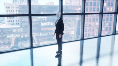 Boş ofiste kalan ve pencereden büyük şehre bakan bir insansı robot. gelecek teknoloji konsepti.