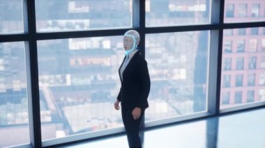 Boş ofiste kalan ve pencereden büyük şehre bakan bir insansı robot. gelecek teknoloji konsepti.