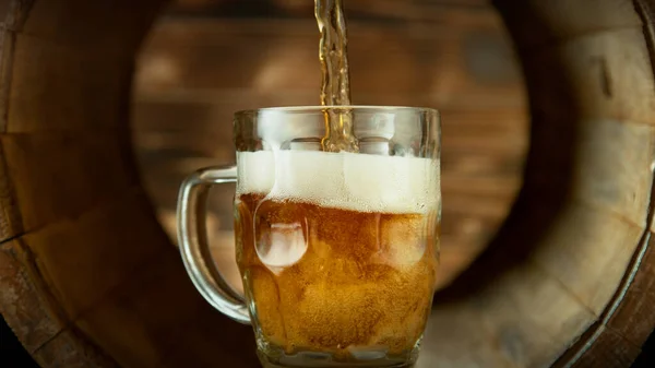 把啤酒倒入旧木桶里的杯子里 新鲜饮品的概念 — 图库照片