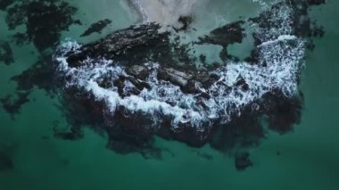 Taşlı deniz dalgalarının hava yavaş çekim görüntüleri. Hava aracı görüntüsü, güzel vahşi doğa 4k video arkaplanı. Kamera yukarı doğru hareket ediyor.