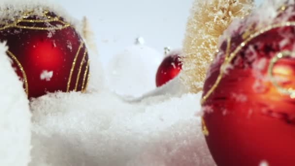 クリスマスのガラス玉で雪が降るの超スローモーション スライダーでカメラの動き 高速シネマカメラで撮影 — ストック動画