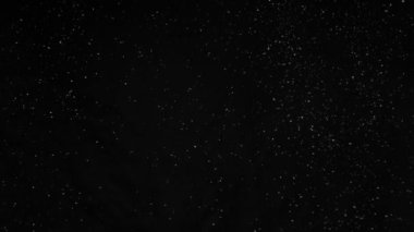 Siyah zemine düşen kar tanelerinin süper yavaş çekimi. Yüksek hızlı sinema kamerası, 1000fps.