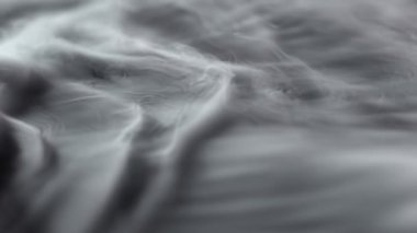 Siyah arkaplanda izole edilmiş beyaz duman dokusu süper yavaş hareket ediyor. Yüksek hızlı sinema kamerasıyla çekilmiş..