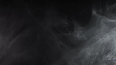 Siyah arkaplanda izole edilmiş beyaz duman dokusu süper yavaş hareket ediyor. Yüksek hızlı sinema kamerasıyla çekilmiş..