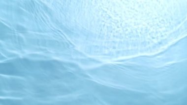 Su yüzeyinin çok yavaş hareket etmesi detaylıdır. Yüksek hızlı sinema kamerası, 1000 fps. Havuzda suyun dokusu, yukarıdan çekilmiş..