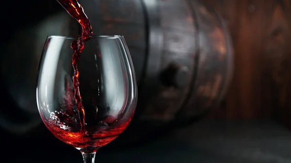 Despejando Vinho Tinto Copo Com Barril Madeira Fundo — Fotografia de Stock
