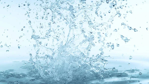 水花在柔软的蓝色背景上被隔离 水在空气中爆炸的冻结运动 — 图库照片