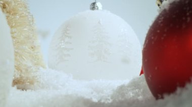 Noel cam toplarıyla yağan karın süper yavaş çekimi. Kaydırma üzerinde kamera hareketi. Yüksek hızlı sinema kamerasıyla çekilmiş..