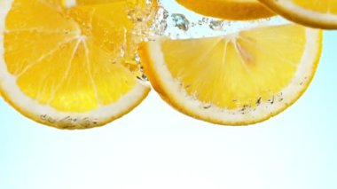 Super slow motion of falling orange slices into water. Filmed on high speed cinema camera, 1000 fps.