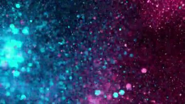 Super slow motion of glittering neon particles on black background. Shallow depth of focus. Abstract shimmering background with glows.
