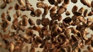 Siyah arka planda kahve çekirdeklerini döndürmek için süper yavaş çekim. Yüksek hızlı sinema kamerasında çekildi, 1000 fps yüksek hızlı sinüs robotuna yerleştirildi. Kamera dönerek yukarı çıkıyor. Hız rampası etkisi.