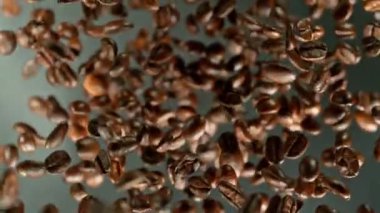 Siyah arka planda kahve çekirdeklerini döndürmek için süper yavaş çekim. Yüksek hızlı sinema kamerasında çekildi, 1000 fps yüksek hızlı sinüs robotuna yerleştirildi. Kamera dönerek yukarı çıkıyor. Hız rampası etkisi.