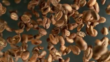 Siyah arka planda kahve çekirdeklerini döndürmek için süper yavaş çekim. Yüksek hızlı sinema kamerasında çekildi, 1000 fps yüksek hızlı sinüs robotuna yerleştirildi. Kamera dönerek yukarı çıkıyor. Hız rampası etkisi.