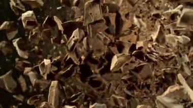 Ham çikolata parçalarının dönüşümlü süper yavaş çekimi. Süper hızlı kamera hareketi. Yüksek hızlı sinema kamerasında çekildi, 1000fps, yüksek hızlı sinüs robotuna yerleştirildi. Hız rampası etkisi.