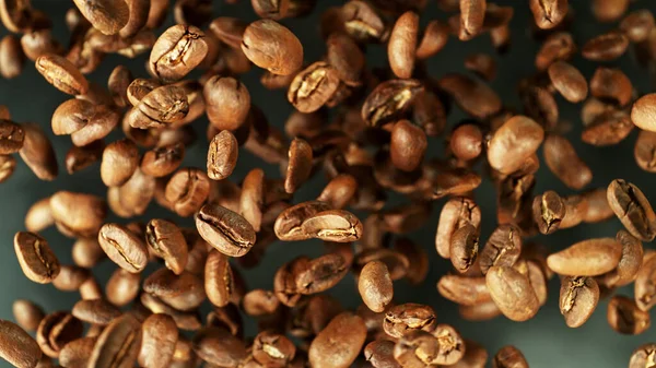 冷たい動きの中で空気中を飛ぶコーヒー豆 焙煎豆と抽象コーヒーの背景 — ストック写真