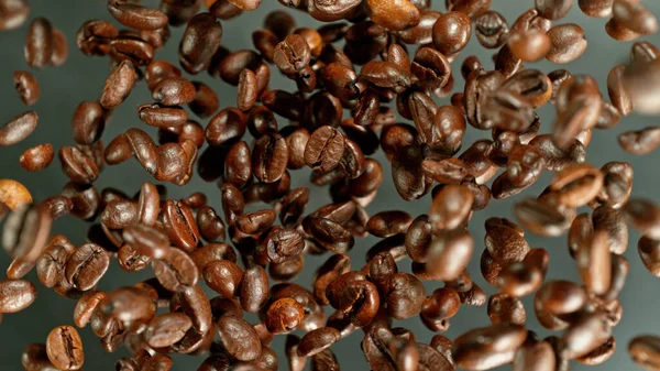 冷たい動きの中で空気中を飛ぶコーヒー豆 焙煎豆と抽象コーヒーの背景 — ストック写真