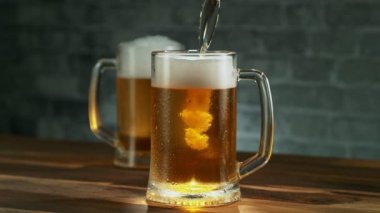 Birayı eski mahzen arka planında cama dökmenin süper yavaş çekimi. Yüksek hızlı sinema kamerası, 1000 fps..